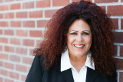 Headshot of Lauralee Ensign, white woman with curly brown hair