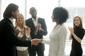 Grateful boss handshaking promoting African businesswoman congratulating with career achievement