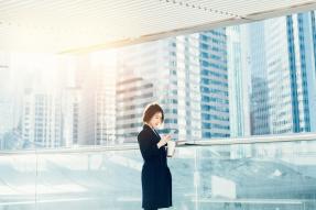 Asian business woman reading phone in city scape