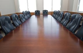 Empty boardroom table and chairs