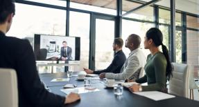 Professional businesspeople sitting in an office watching a video conference