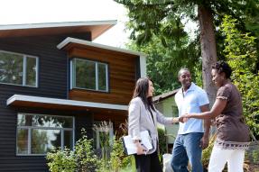 Couple Shaking Hands in Front of New Home