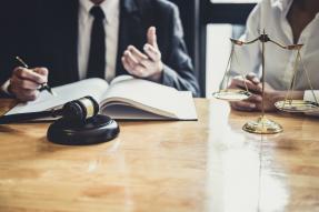 Midsection Of Lawyers Discussing At Desk In Courthouse