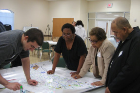 People looking at a county map laid out on a table 