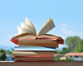 Pile of books with pages open by wind 