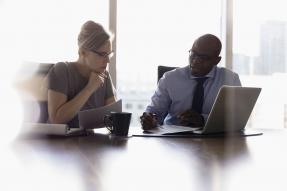 Woman and Man Consulting in Front of Bright Window