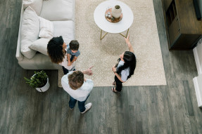 High angle view of agent showing living room to a family