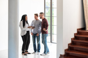 Agent showing a home to a male couple