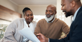 Agent showing documents to an older couple in their living room