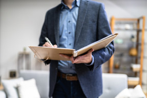 Appraiser in home writing in a notebook