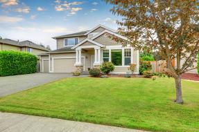 Beige house with a big lawn, blue sky