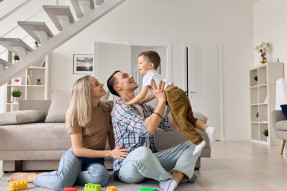 Cheeful young couple with kid in modern home