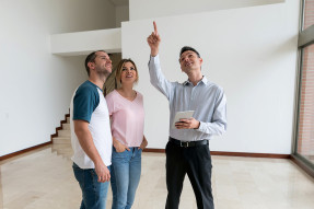 Clients and agent in home, looking at the ceiling