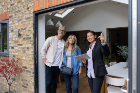 Clients and real estate agent in house looking at back yard