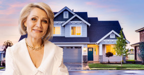 Close up of older professional woman with a house in the background