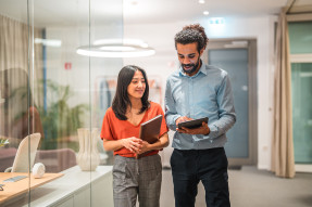 Colleagues in an office looking at a tablet