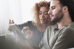 Couple sitting on a couch using a tablet