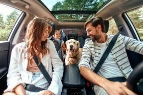 Family in a car with their dog