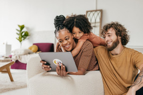 Family in living room looking at a tablet