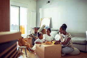 Family in living room with moving boxes