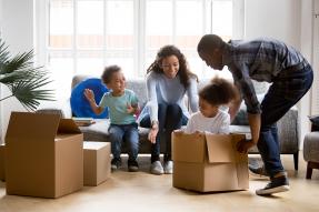 Family unpacking boxes in living room