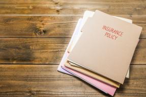 Insurance Policy file folders on table