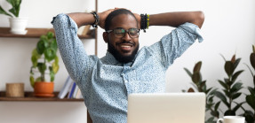 Businessman leaning back in chair looking at computer screen