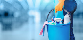 cleaning lady standing with a bucket and cleaning products