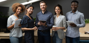 Group portrait of smiling multiethnic team posing in office