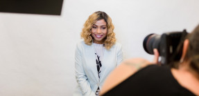 Woman smiles as photographer takes headshots