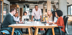 Diverse people sitting around a conference table in office