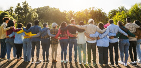 Group of people forming a line with arms around each other