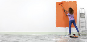 Woman painting a wall orange