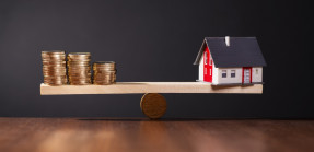 Scale with coins and house model