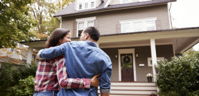 young couple in front of house