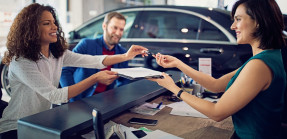 Couple is buying new car and signing the contract