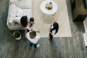 A high angle view of a female Real Estate Agent showing a home to a young couple.