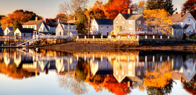 Lakeside homes in fall with reflections on water