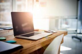 Laptop on Rustic Desk with Lens Flare