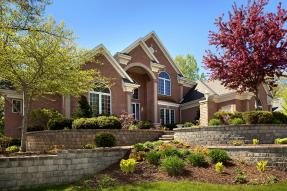 Large modern brick house with landscaping, in spring