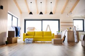 Living room with moving boxes and yellow couch