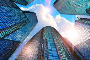 Looking up at tall office buildings and blue sky