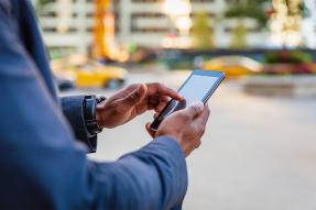 Man on street using a cell phone