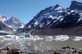 Melting frozen lake and snow covered mountains