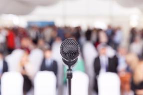 Microphone in front of blurred conference audience