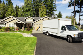 Moving van in the driveway of a house