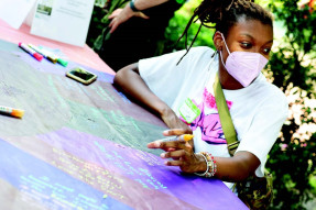 Black woman writing on a board using art-engagement tools