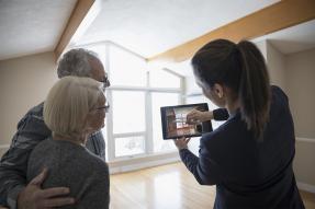 Agent and clients in an empty house using a tablet