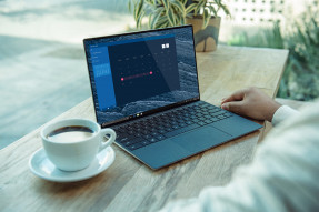 Person at a desk with coffee and laptop