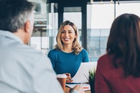 Professional woman at desk with clients